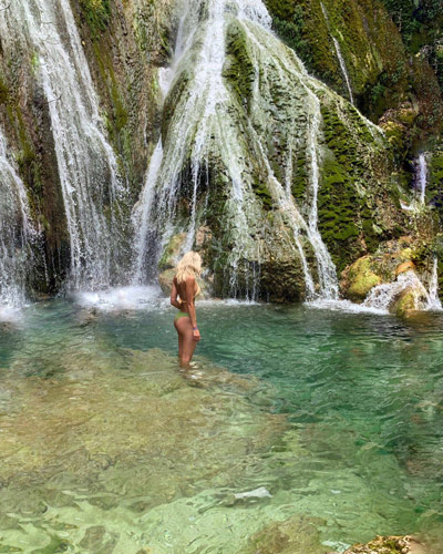 swimming under a waterfall in vanuatu