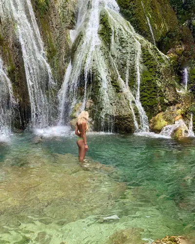 swimming under a waterfall in vanuatu