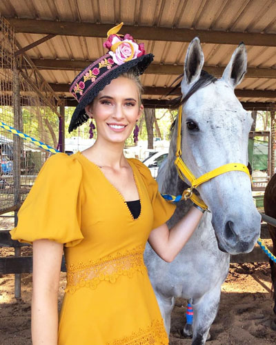 mustard race dress next to white grey horse