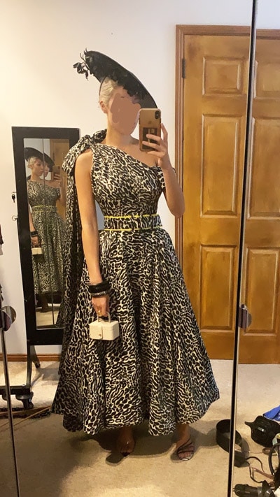 trying dress at home in front of mirror black leopard print dress