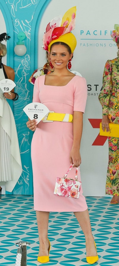 pastel pink dress with yellow crown fascinator and yellow belt and shoes